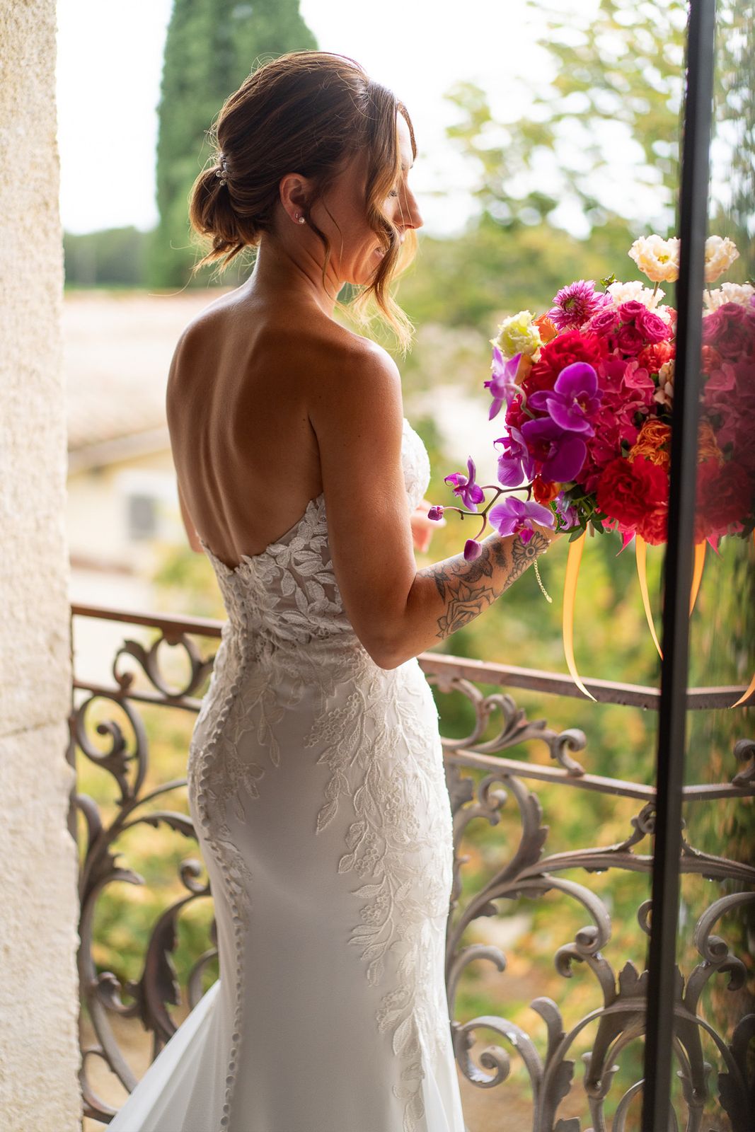 Bouquet de la mariée aux fleurs roses, fuchsia et orange lors des préparatifs